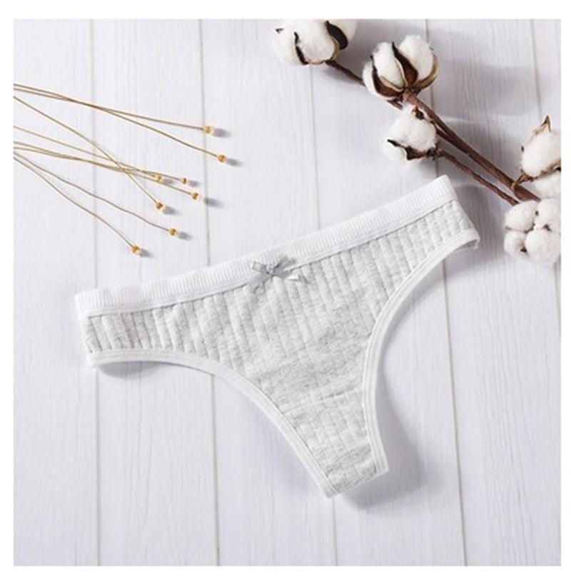  Women Panties in pink ribbed cotton with bow detail on a wooden background.
