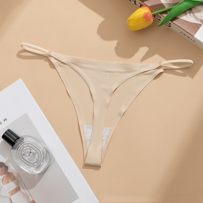 Seamless panties Ice Silk pant in beige color laid flat with a floral accent and a bottle of perfume.