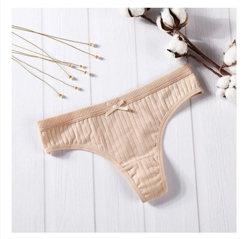  Women Panties in pink ribbed cotton with bow detail on a wooden background.
